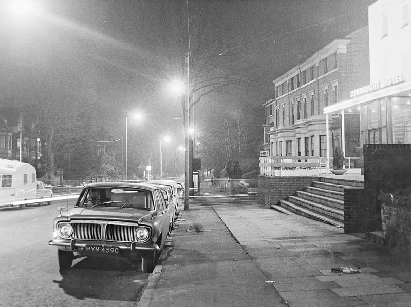 Streetlamps glow along Tettenhall Road in Wolverhampton outside the entrance to the Connaught Hotel in November 1966. Classic saloon cars sit parked by the pavement, accompanied by a touring caravan across the way, capturing an atmospheric snapshot of the town at dusk. Do you remember visiting the Connaught Hotel or driving along Tettenhall Road back in the mid-1960s?