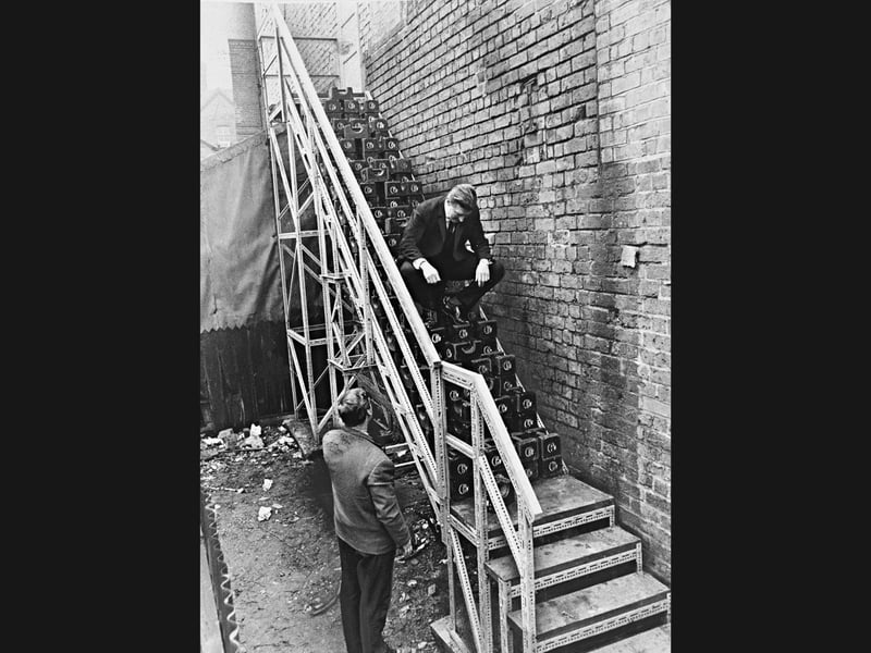 Managing director J R Bickford sits perched atop a metal fire escape laden with heavy weights to test its structural strength in March 1966. Looking on from below is general manager John Latham at the back of the former Olympia Cinema on St George's Parade, Wolverhampton, where the apparatus was installed by Abecalt General Engineering Co. Do you remember Abecalt Engineering or the old Olympia Cinema building in Wolverhampton back in the 1960s?