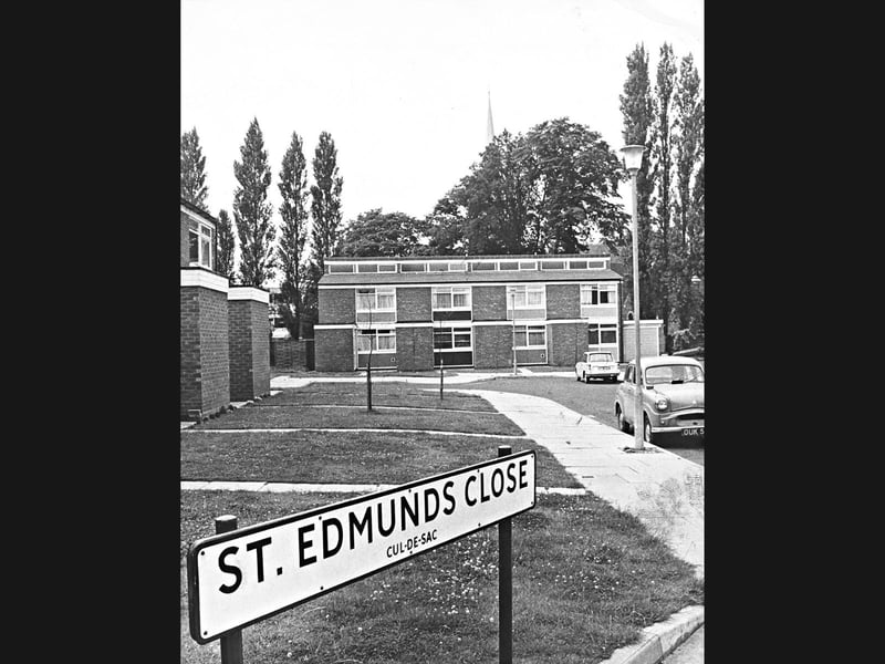 A prominent street sign marks the entrance to St Edmunds Close, Wolverhampton, in July 1966. Modern residential blocks, neatly lawned gardens, and parked cars line the cul-de-sac, with a church spire peeking over mature trees in the background to complete this tranquil mid-60s suburban scene. Do you remember the close looking as neat and peaceful as this back in 1966?