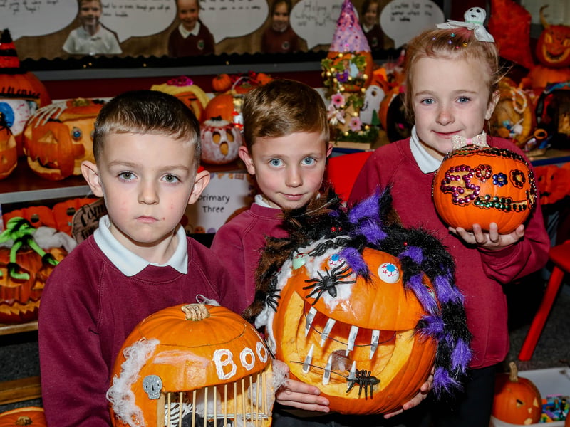 Louis, Leon and Katie, P3 pupils at Bush PS, with their entries in the schools pumpkin carving competition. AM264411