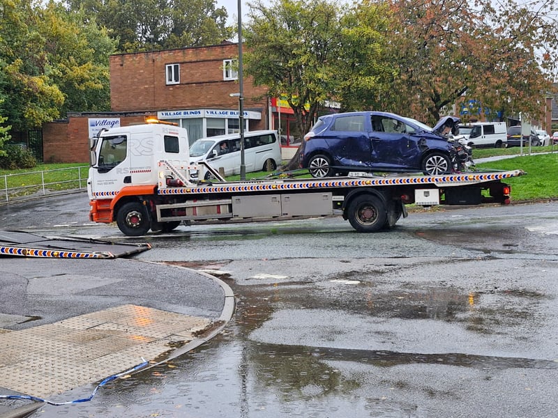 The recovery team take the car away after working to get it out of the store