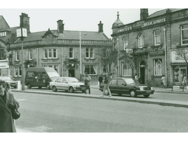 	
A photograph taken looking across St. James's Street towards the White Lion Pub and Yates's Wine Lodge, which were both located at the end of Parker Lane. 