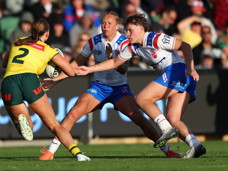 Wigan duo Anna Davies (left) and Molly Jones (right) tackle Australia's Jaime Chapman