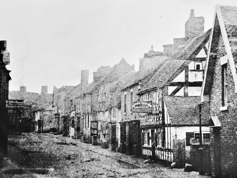All that is written on the back of this print is "Oldest pic of Market Drayton?" It is Cheshire Street, and on the right is the Royal Oak Inn (the licensee's name looks something like Blockley), and on the left is the Drovers Arms (licensee's name is Roden). Immediately below that pub sign is what looks like the Butter Cross. If this really is the oldest picture it may be from around the 1850s and the absence of people will be deceptive, as they will have been rendered invisible thanks to a long exposure time. This same picture  was used in the Newport and Market Drayton Advertiser of May 1, 1964, which described it as being 100 years ago, which would make the date 1864, which is rather late for an "oldest picture." 
