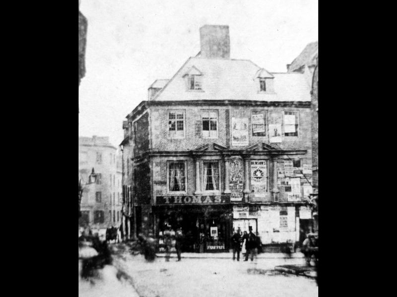 Mardol Head, Shrewsbury, probably in the early 1860s and certainly before around 1867, as these buildings were among those knocked down to make way for the Victorian Shrewsbury market hall. The photographer has his back to Pride Hill, and you are looking down Shoplatch. The George Hotel is on the left in the distance. Thomas's was a toy shop. The pillars on the first floor windows were taken to Court House, Mountfields, but do not survive today.
