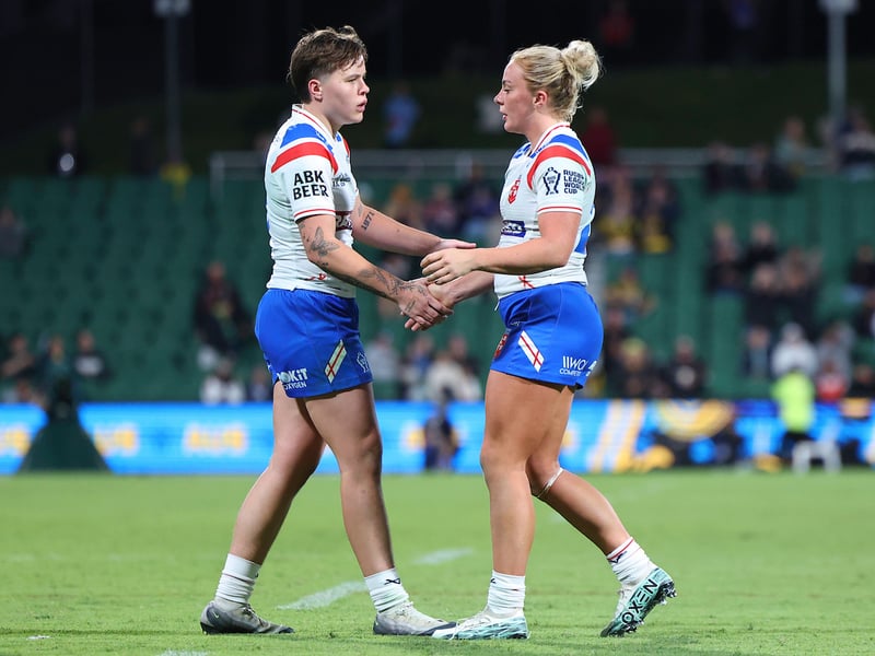 Wigan centre Molly Jones (left) shakes hands with England teammate Lucy Murray (right) after their defeat to the Jillaroos