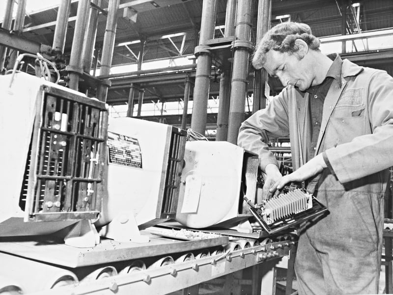 Roller conveyors, delicate wiring, and industrial framework, this July 1982 photograph captures a skilled engineer assembling generators at the Electric Construction Ltd works in Wolverhampton. Formed initially in 1882 by Thomas Parker in a small corner of the Patent Tip and Horse Shoe Company premises, the firm was celebrating its centenary as a renowned engineering manufacturer. The worker, clad in company overalls, completes fine adjustments on an electrical unit destined for export to the Far East, showing the continuing legacy of high level Black Country precision engineering. Do you remember working on the production lines or fitting benches at Electric Construction Ltd? Who recalls the global reputation of Wolverhampton manufactured electrical apparatus and heavy plant machinery during the early 1980s?