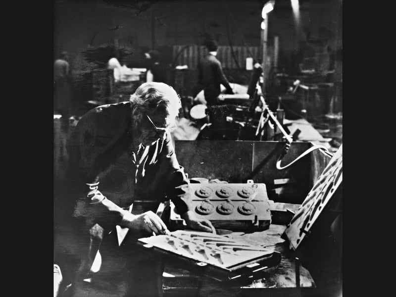 Casting sand, intricate metal moulds, and the focused gaze of a master craftsman, this January 1982 photograph captures Joseph Haynes at work inside the Chadd Foundry in Wolverhampton. Founder of the 40 year old foundry, Haynes is seen preparing moulds to craft hand cast brass period English door fittings, including knockers, knobs, levers, and letterboxes. Partnering with the newly formed Stafford Mills and Trading company, the venture aimed to champion traditional local metalwork, generate skilled employment, and combat a wave of cheap foreign imports flooding the British market. Do you remember working in the foundries or metal trades across Wolverhampton during the early nineteen eighties? Who recalls buying authentic hand cast brass fittings crafted by local Black Country makers?