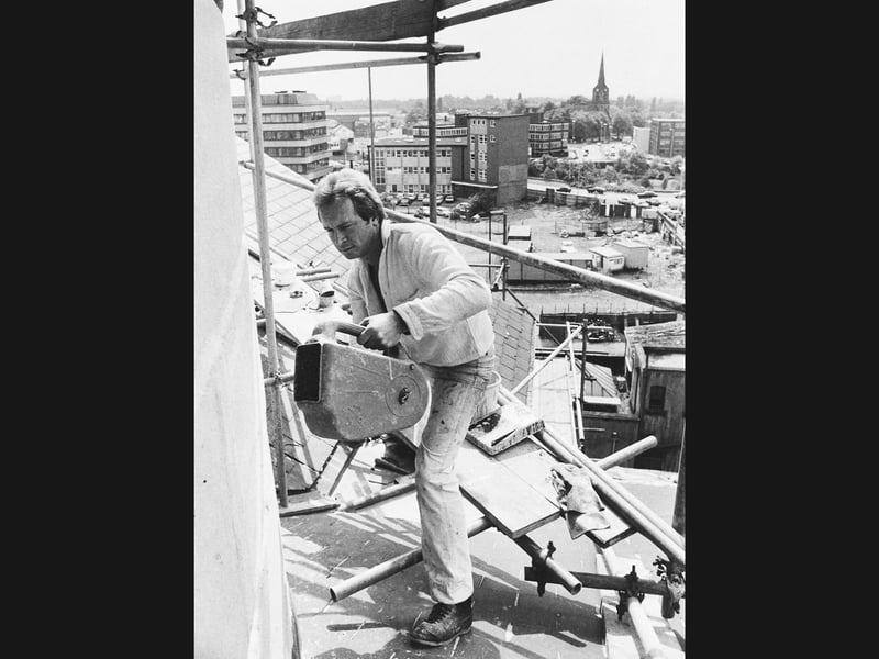 Scaffolding planks high above the rooftops, specialised spraying machinery, and wide town vistas, this June 1982 photograph captures foreman mason John Algar hard at work restoring Darlington Street Methodist Church. Perched fearlessly above the streets, Algar helped clean away more than a century of industrial grime from the 1860 church exterior before applying a coating of resin and coloured sand to recreate its original sandstone appearance. Framing the craftsman, the Wolverhampton skyline stretches out towards distant spires and modern office blocks, showcasing the skilled restoration efforts dedicated to preserving the town's historic landmarks. Do you remember seeing the scaffolding wrapped around Darlington Street Methodist Church during its 1982 restoration? Who recalls watching the stonework brighten up as decades of town centre grime were finally washed away?