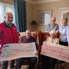 Cecil Darragh and his late wife, Emily, pictured presenting the proceeds from their recent 60th wedding anniversary and Mr Darragh's 90th birthday to representatives of Air Ambulance NI and Cancer Research UK.