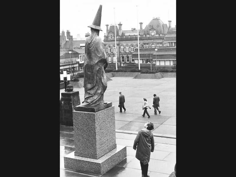 Passers-by in St Peter's Square, Wolverhampton, pause in amusement as a mystery prankster's handiwork tops the bronze statue of the town's founding benefactress in February 1982. Perched precariously like a sorcerer's cap, a bright road traffic cone gave Lady Wulfruna an unexpected new look, though the historic figure seemed to take the cheeky addition in stride as pedestrians hurried past. Do you remember spotting this mischievous prank on Lady Wulfruna back in the late winter of 1982?