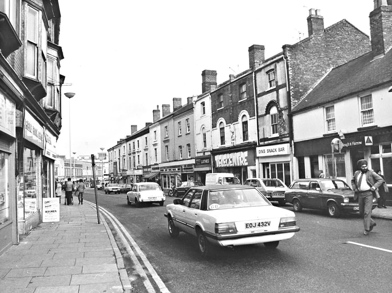 Traffic moves past independent shopfronts and shoppers stroll the pavements along Worcester Street in March 1982. Recognised as one of Wolverhampton's historic retail thoroughfares, the street continued not only to survive but to thrive amidst modern developments, lined with familiar local stops including the Plough & Harrow, Din's Snack Bar, and Telecentre. Do you remember browsing the shops or stopping for a bite along Worcester Street in the spring of 1982?