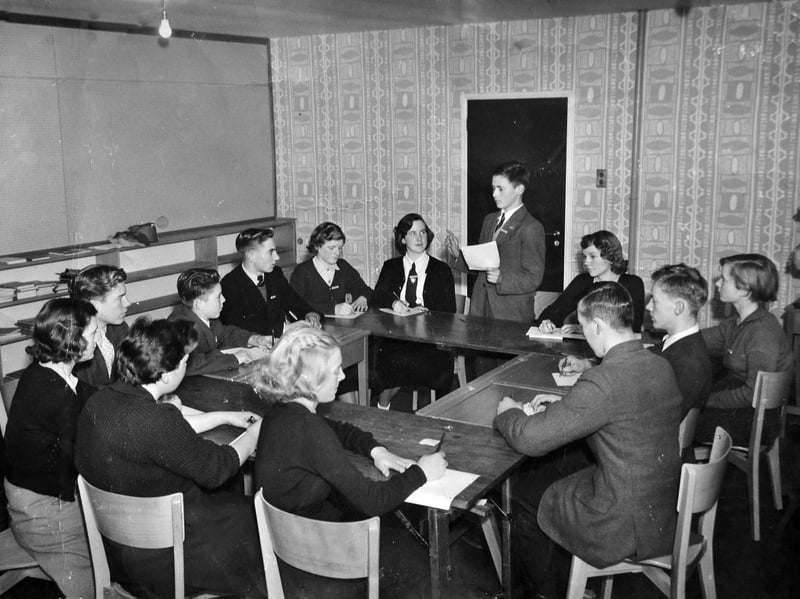 Young Jim Yates, who was born in 1941, is the young lad on his feet, addressing a council meeting of Dawley Secondary Modern School. He was its chairman. Jim thought the picture dated from 1955-56 and, as the school opened in September 1956, it must be the latter year, meaning these are some of the first ever pupils at the new school. He had been to Pool Hill School previously. He lived at 3 Harp Lane, Dawley. He would recall: "The councillors took over from the prefects at the new school. Going clockwise, Jim Yates (standing), Leonora Tonks, Jean Vickers, Derek Payne, Bill Guest, Barbara Horler, Pat Burford, Marian Hassel, Bob Upton, Barry Spurway, Terry Skelton, Brenda Gough and Margaret Clift."