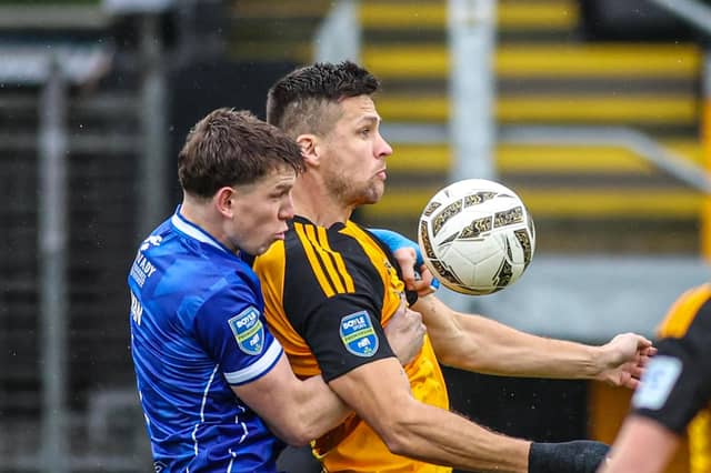 Limavady United’s Tiarnan Boorman and Carrick Rangers’ Adam Lecky compete for possession.