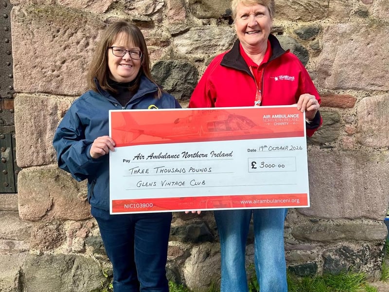 A member of Glens Vintage Club presents a cheque to Air Ambulance NI