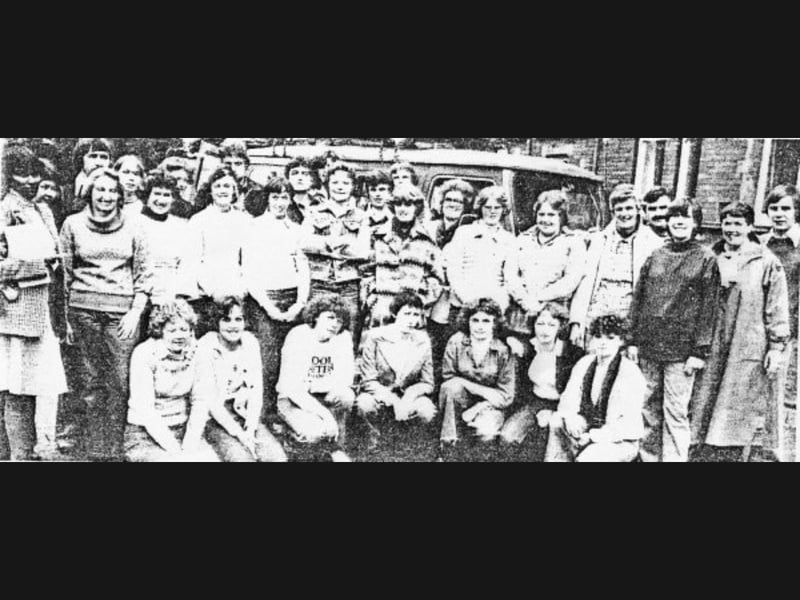 A large group of students from Radbrook College assemble outside during the 1977 to 1979 era, featuring Tina Hughes, Kevin Skeet, Colin Pound, Sue Holloway, Sue Kelly, and Julie Upton across the front, with Jeremy Blakely standing just behind Sue Holloway. Do you recognise yourself or any old friends standing in this Radbrook College class photo from the late '70s? What do you remember most about student life, lessons, and college trips during your time in Shrewsbury back then?