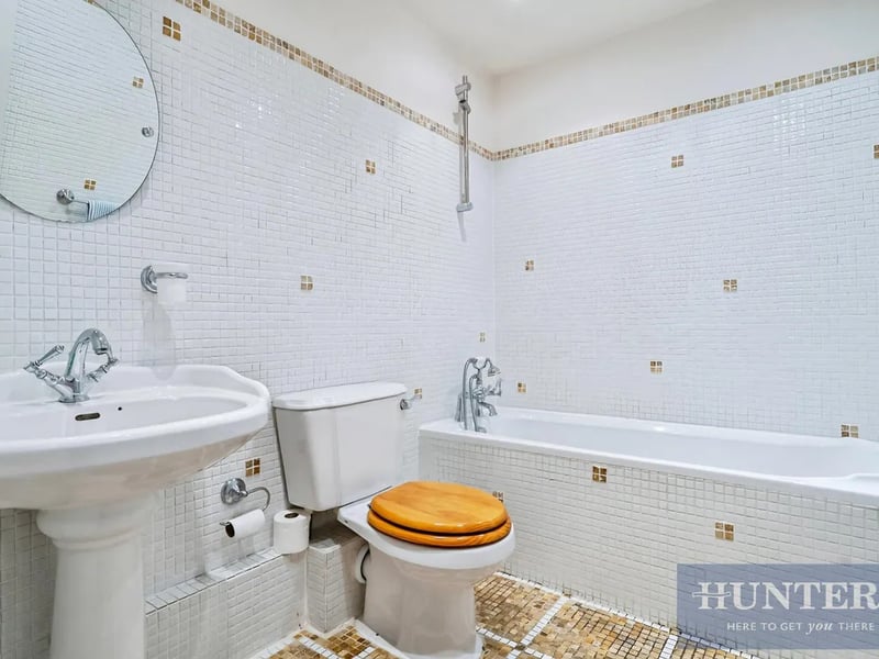 The other bathroom is adorned in decorative mosaic tiling.