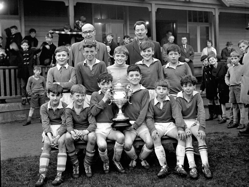 Team picture of the St Patrick's Primary School football team with a trophy in April 1964.