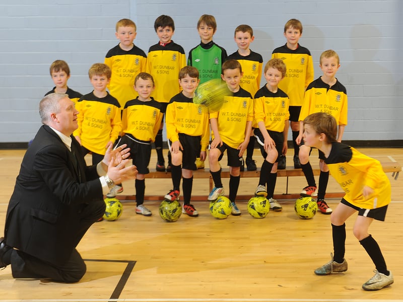 Kevin Duffy from WT Dunbar Funeral Services throws the ball to Fox Covert Primary's Harvey Thomson as the firm announced their sponsorship of the football team in November, 2011.