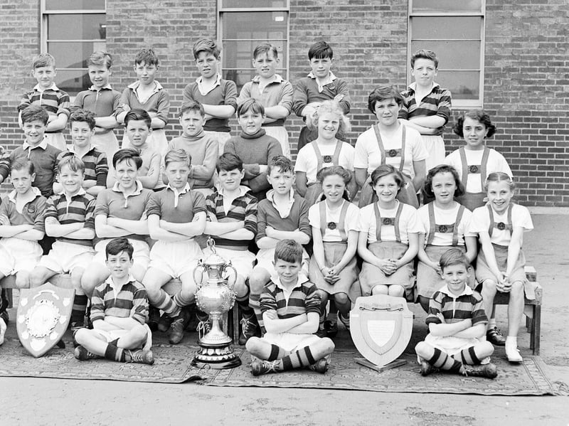 Boys of Royston Primary School with the Leith Schools Cup and Mackie Shield they won for football, and the girls with the netball Wardie Parents' Association Shield, in May, 1952.