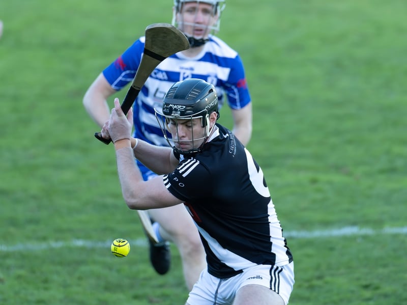 Maynooth star Cathal McCabe clears his lines as Brian Byrne of Naas gives chase