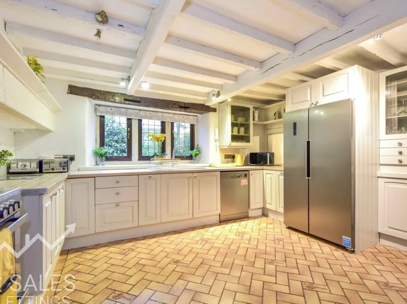 The spacious farmhouse kitchen is equipped with plenty of storage cabinets.