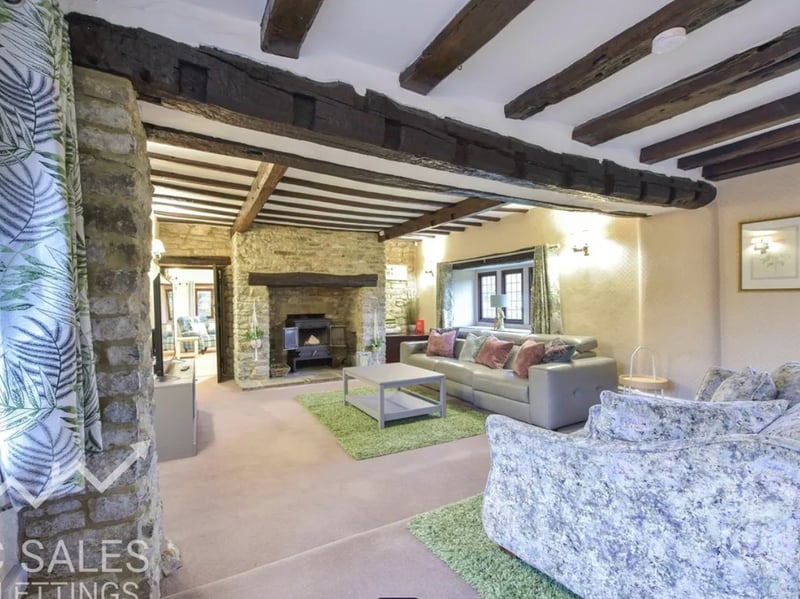 Characterful lounge where focal points include the ceiling beams and exposed stone fireplace.