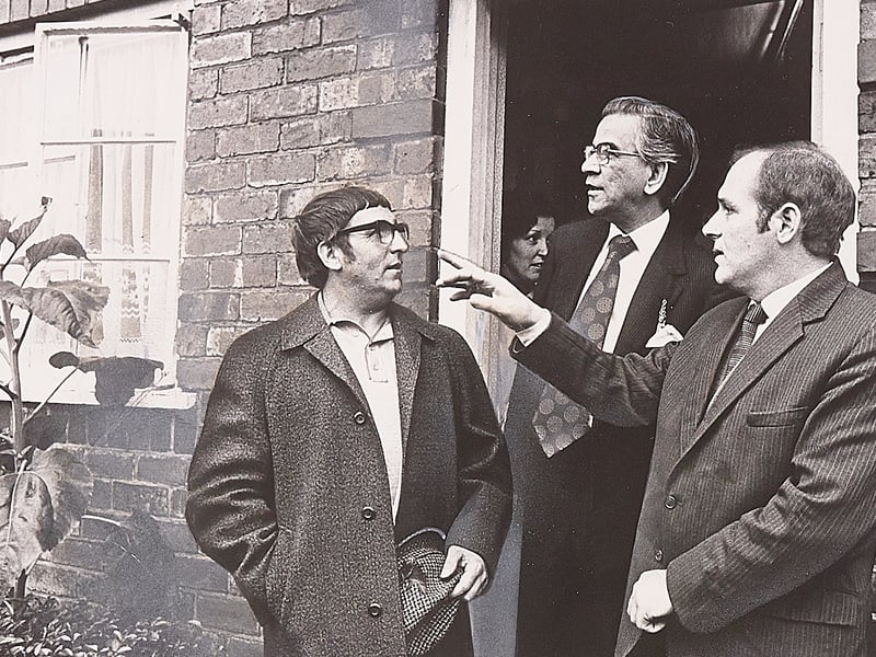 The Mayor of Sandwell, Dr Hiren Roy (centre), listens intently alongside Frank Guy of the tenants' action committee as local resident William Mullinder (left) points out structural issues outside a home in Allen Road, Tipton, in October 1976. Following persistent complaints from residents on the Princes End estate regarding poor living conditions and outdoor toilets, the mayor inspected properties firsthand and urged the council's housing committee chairman to meet with families to resolve the modernisation crisis. Do you remember the campaign for better housing across Princes End or living on Allen Road back in the autumn of 1976?