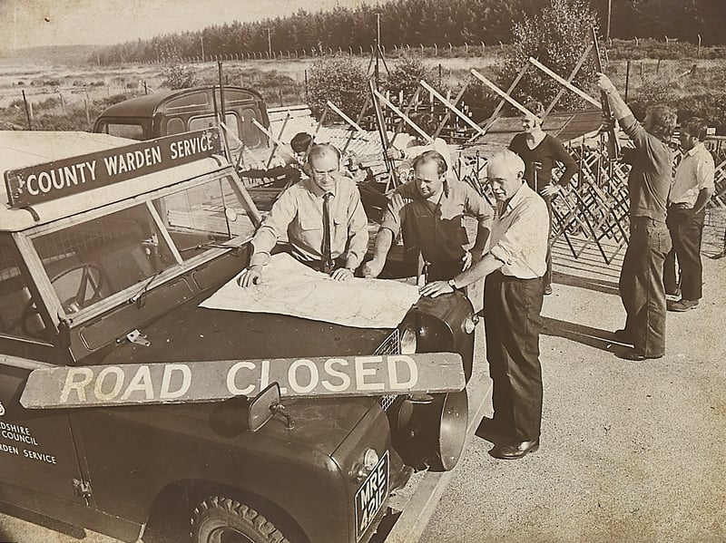 Assistant principal planning officer David Wright (left) confers over a map spread across the bonnet of a County Warden Service Land Rover with wardens on August 4, 1976. Marking the 35th day of the punishing summer heatwave, authorities took the unprecedented step of shutting the tinder-dry beauty spot to the public. In a coordinated effort to stop wildfires tearing through 2,700 acres of open countryside, access routes were barred with "Road Closed" barriers and "Keep Out" signs were posted across the perimeter. Do you remember Cannock Chase being placed under total lockdown during the scorching drought of August 1976?