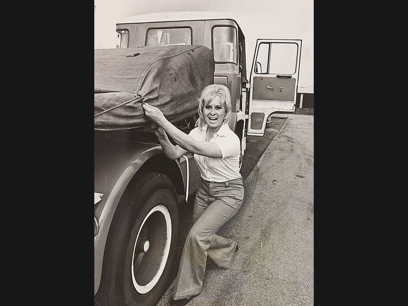 Sue Green smiles as she secures a tarpaulin over the load of a heavy lorry in May 1976. Tiring of desk work at her family’s haulage firm in Burntwood, Sue decided on a fresh direction and stepped behind the wheel of a 12-ton truck. Encouraged by friends and her husband Paul, she passed her driving test and took to piloting HGVs with fully loaded rigs reaching up to 32 tons—turning heads across the roads of Staffordshire. Do you remember seeing Sue handling the big lorries around Burntwood during the spring of 1976?