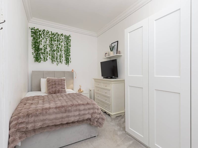The second double bedroom is also located to the front, with both bedrooms featuring soft carpeting. A study/boxroom provides an ideal home office, with a series of fitted cupboards and an adjoining storage room offering further practical space. The stunning main bathroom completes the internal accommodation.