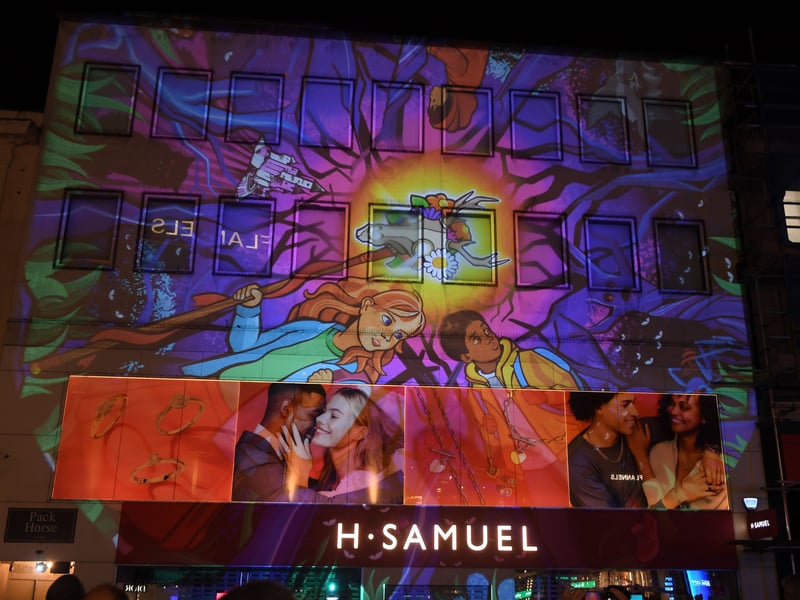 Shops on Briggate are lit up with projections.