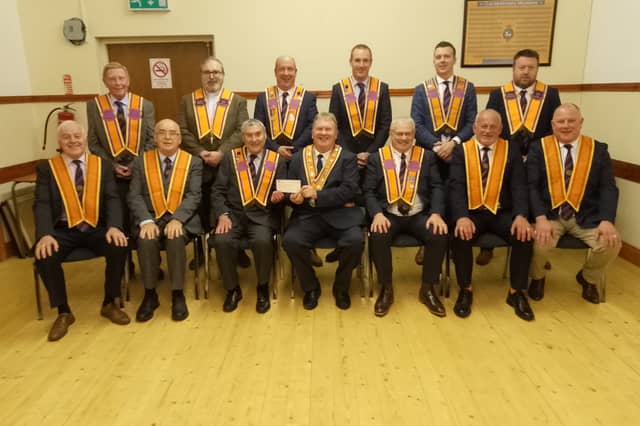 The Grand Master receiving the cheque from Wor Bro Samuel Courtney BEM, Worshipful District Master, accompanied by Rt Wor Bro Denis Watson, County Grand Master, and his Officers, also the Newtownhamilton District Officers.