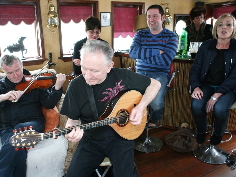 John Carty and Donal Lunny accompany singer  Fionnuala Maxwell on the barge to Jamestown in 2012.