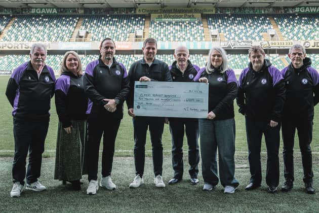 NI Football League Media and Communications Lead Gareth McCullough presents a cheque for £4989 to charity partners Players Against Dementia.