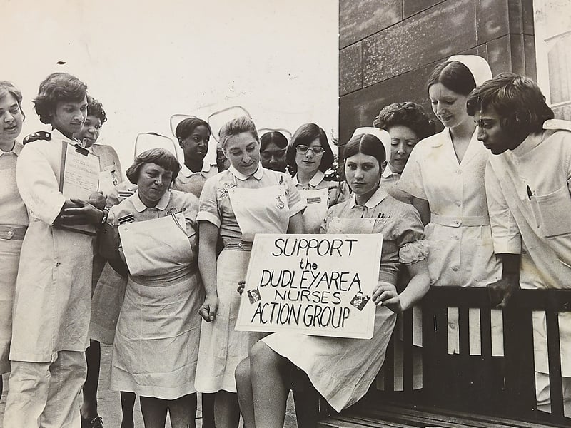 Student nurse M Forsyth sits holding a placard for the "Support the Dudley Area Nurses Action Group" surrounded by fellow nursing staff gathered in uniform in June 1974. As disputes over pay and conditions escalated across the region, nearly 2,000 hospital workers across the West Midlands threatened strike action unless the Government’s pay inquiry reported back by month's end. Led by student nurses, staff rallied together in support of their claim for fair wages and better working environments, preparing to take their message directly to the public with a planned march through Dudley town centre. Do you remember the nurses' protests in Dudley or work in the local hospitals during the disputes of 1974?