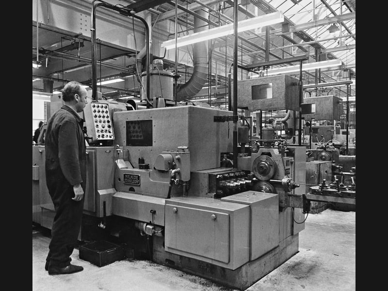 A machinist oversees a heavy cold forging machine fitted with a new glass fibre hood at GKN Screws and Fasteners Ltd in Smethwick in February 1974. The pioneering installation was part of a major contract carried out by Staffordshire Industrial Services Ltd of Wolverhampton, designed to eliminate harmful oil mist pollution from the factory air while significantly cutting down deafening noise levels to comply with strict Factory Act safety standards. Did you work on the shop floor at GKN in Smethwick or remember the introduction of these early workplace safety and air filtration systems during the 1970s?