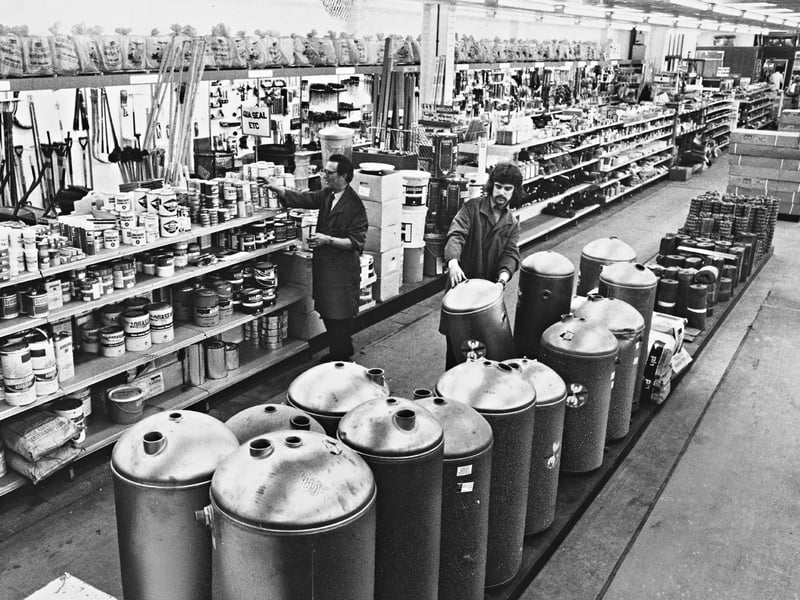 Staff organise aisles stacked high with hot water cylinders, tins of sealant, and building supplies inside builders' merchant Carvers Ltd in June 1974. Showing the resourceful reuse of industrial heritage, Wolverhampton's former Herbert Street goods station had its redundant rail tracks filled in and levelled, transforming the old railway sheds into a spacious and thriving modern warehouse. Did you ever shop for DIY supplies or trade goods at Carvers' Herbert Street depot, or remember the days when trains still rolled into the old goods station?