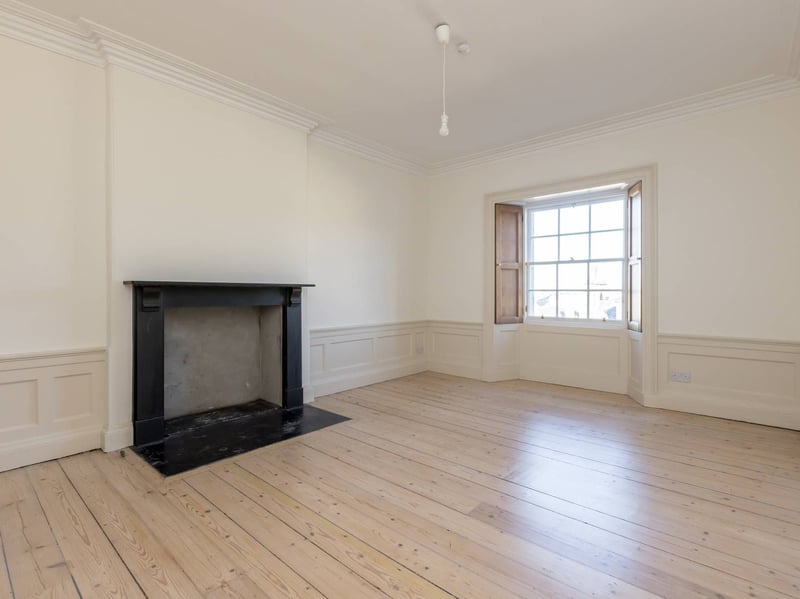 The bright living room with fireplace surround and access to the box room.