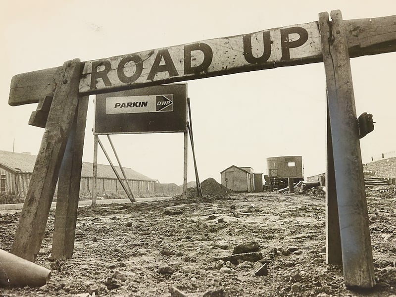 A weathered wooden "ROAD UP" barricade frames an empty, churned-up building plot off Franchise Street in Kings Hill, Wednesbury, in April 1974. Work on the £400,000 "The Furlongs" private housing scheme ground to an unexpected standstill when contractors D W Parkin instructed builders to down tools after estate agents failed to find buyers. Driven by a national mortgage crisis that pushed average monthly repayments to between £80 and £90, developers chose to halt construction on more than 30 planned detached and semi-detached homes rather than erect houses they could not sell. Do you remember when work abruptly stopped on the Franchise Street estate, or recall how the 1974 property slump affected house hunting across Wednesbury?