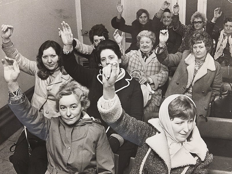Barmaids unanimously raise their right hands during a packed union meeting in Wolverhampton in January 1974. Backed by the Transport and General Workers' Union and supported by Wolverhampton North-East MP Renee Short, around 200 bar workers took collective action across the region after four women working at a pub in Codsall had their pay cut on brewery instructions. Facing resistance from Banks's brewery chiefs over negotiating rights, the militant barmaids issued a 48-hour ultimatum threatening to escalate their campaign and disrupt local beer supplies if fair wage standards were not met. Do you remember the barmaids' dispute or recall local pubs feeling the pinch of the strike action back in 1974?