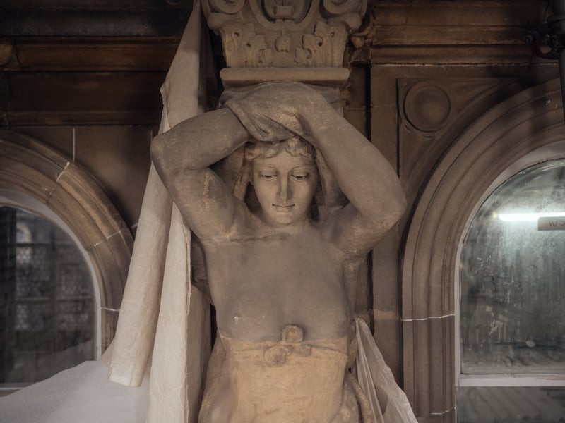 A restored sculpture on one of the building's stone columns