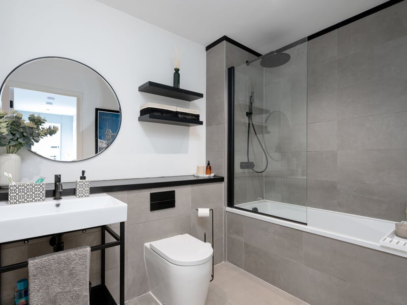 The exquisite three-piece white suite bathroom with shower over the bath.
