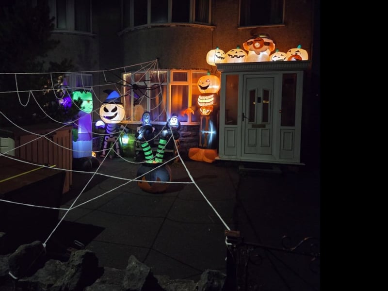 Lit-up grinning pumpkins and a giant cobweb in this garden.