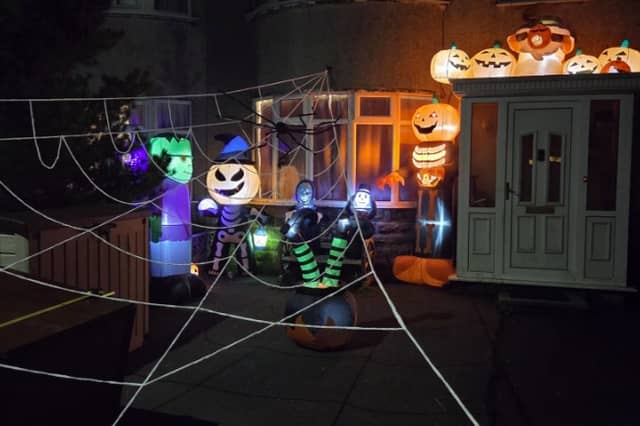 Lit-up grinning pumpkins and a giant cobweb in this garden.