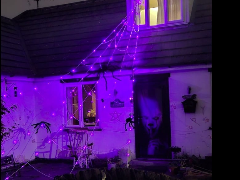 Spiders on a lit-up web and a creepy character on the door.