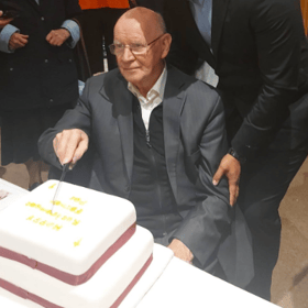 Fr Pat Kenny cutting his retirement cake