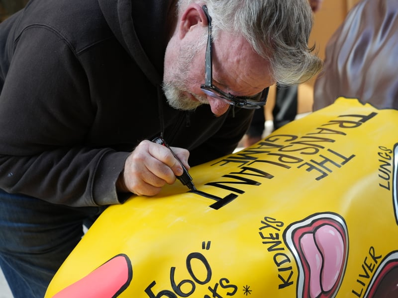 Sheffield artist Pete McKee putting the finishing touches to his lion The Transplant Game for the Pride of Yorkshire trail.